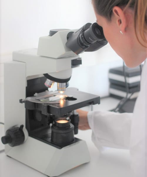 femme qui regarde dans un microscope